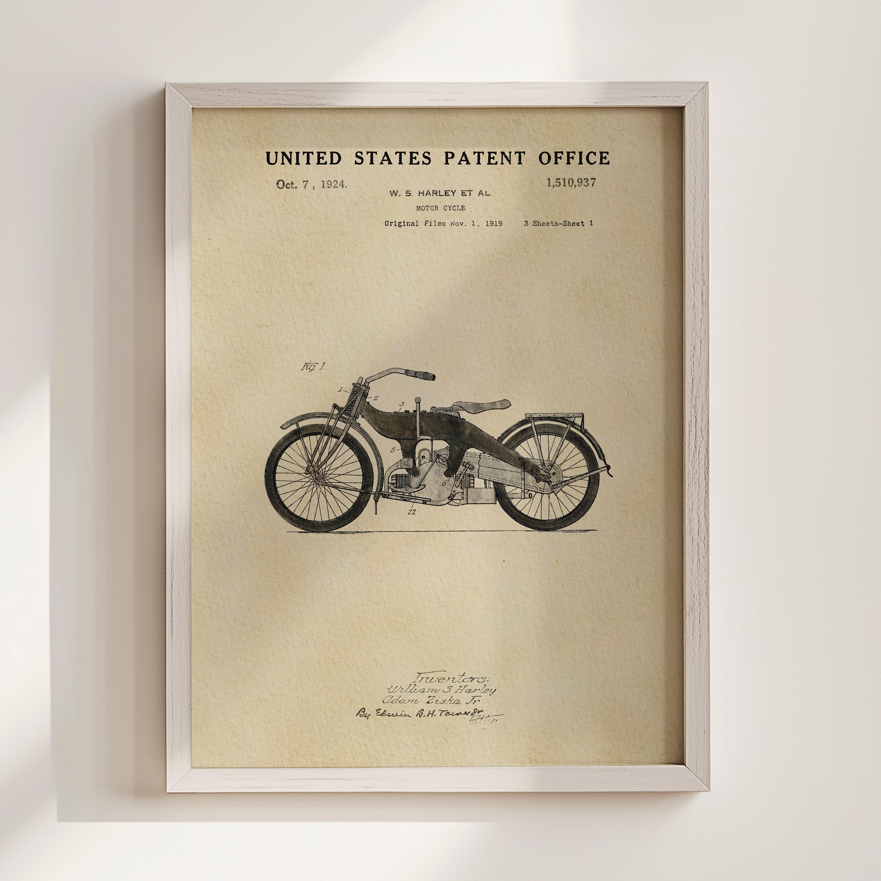The image is a framed patent drawing of a motorcycle, depicting a vintage model with a detailed illustration of its design.