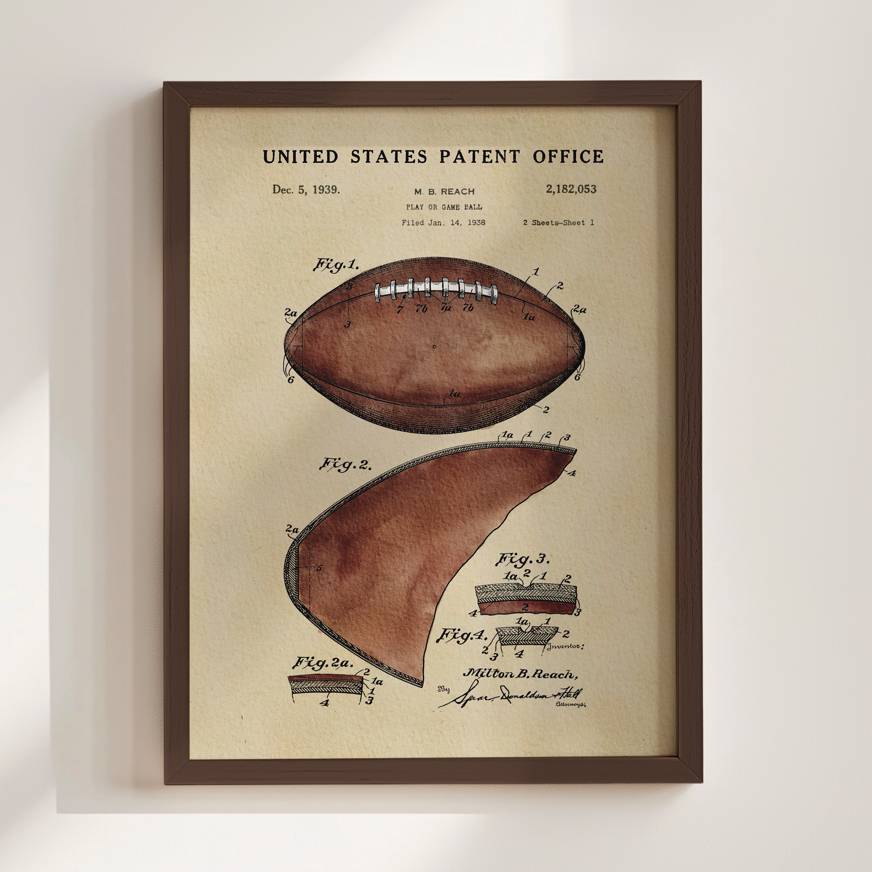 The image is a framed print of a watercolor illustration depicting a football, which appears to be a patent drawing from the United States Patent Office.