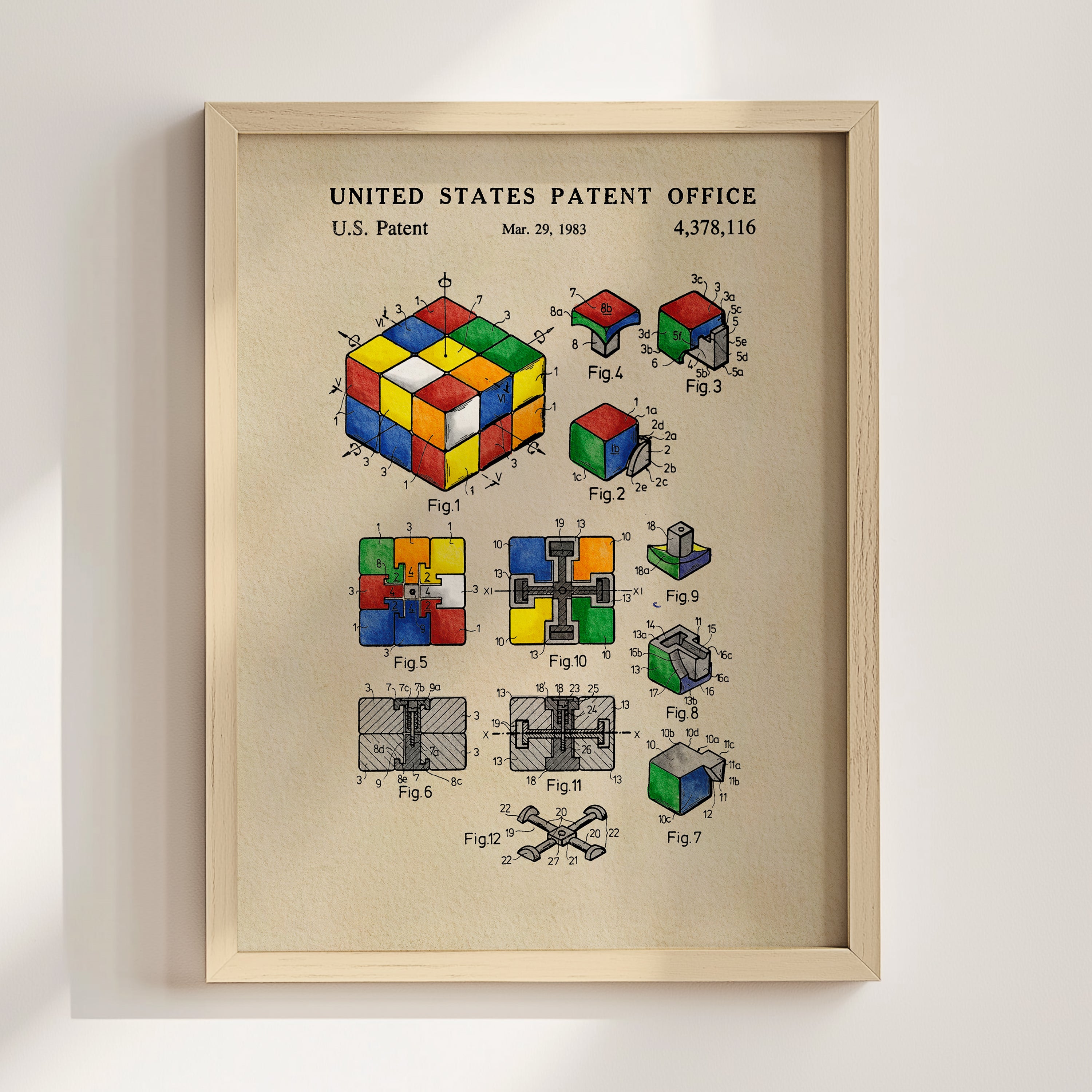 The image is a framed poster featuring a colorful Rubik's cube and various technical drawings and diagrams related to the Rubik's cube, including its components and assembly process.