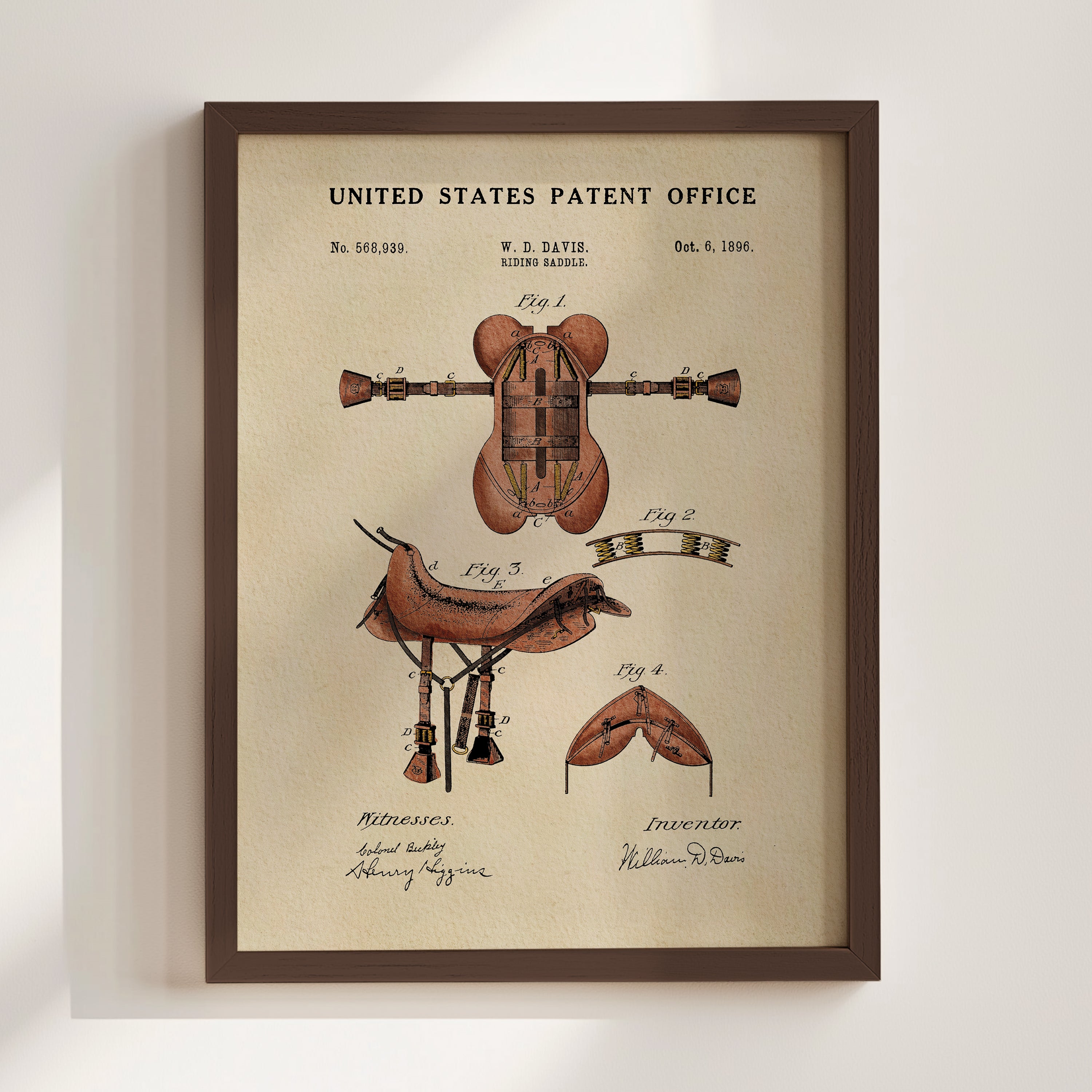 The image is a framed print of a United States patent office patent from 1885, featuring an illustration of a horse saddle and other patent-related drawings.