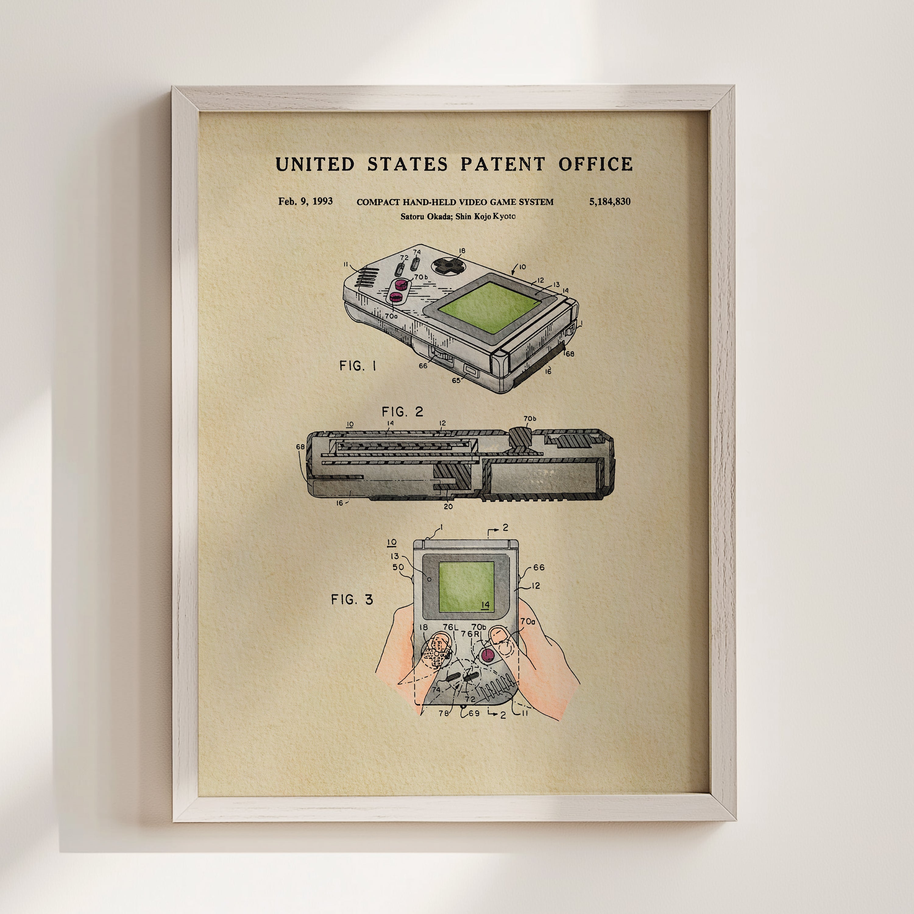 The image is a framed patent drawing depicting a compact handheld video game system, specifically the Gameboy Advance, which was released in Japan in 1990.