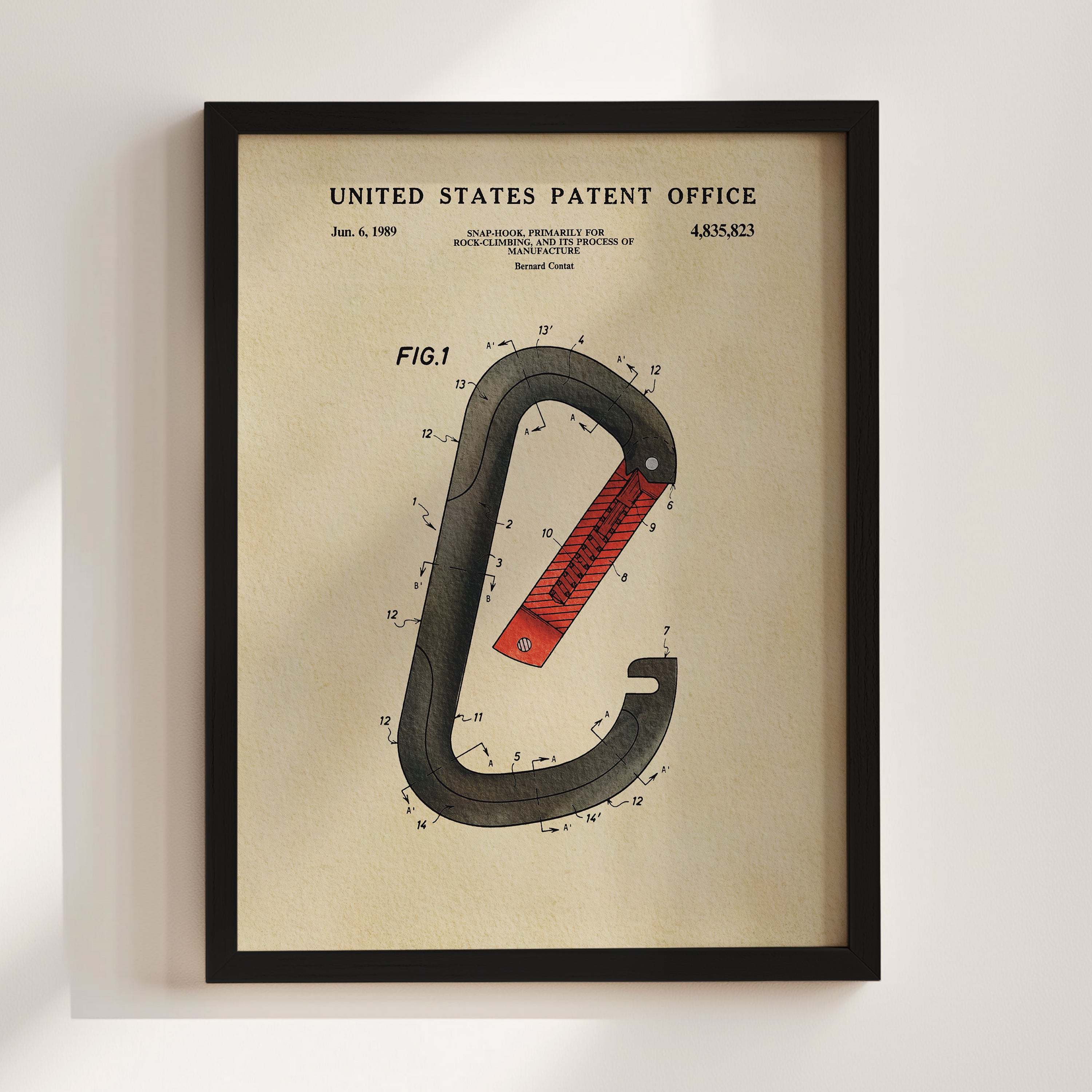 The image is a framed patent drawing depicting a red and black carabiner, a type of hook used for securing items to carabiners.