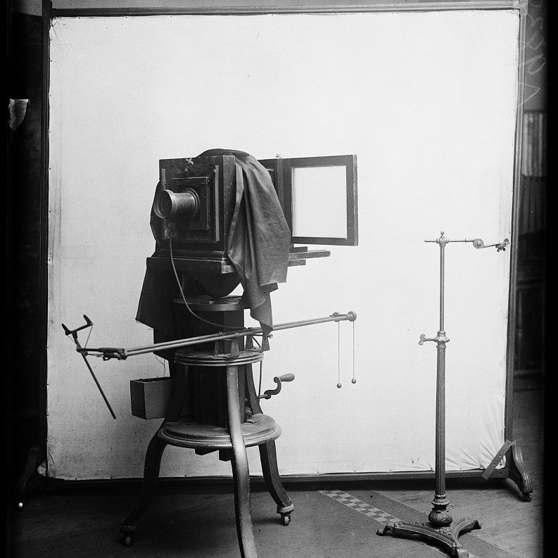 An antique studio view camera on a stand