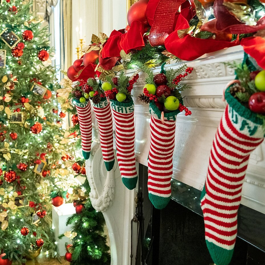 Festive red and white Christmas stockings on a decorated mantel