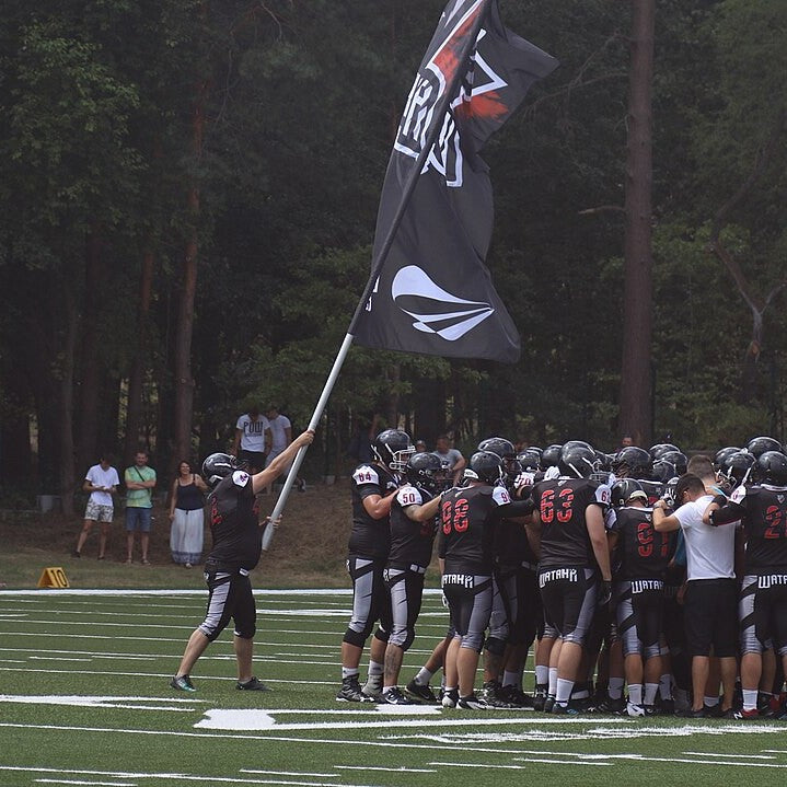 An American football team huddled on the field