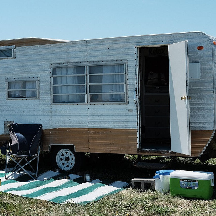 A vintage aluminum travel trailer at a campsite