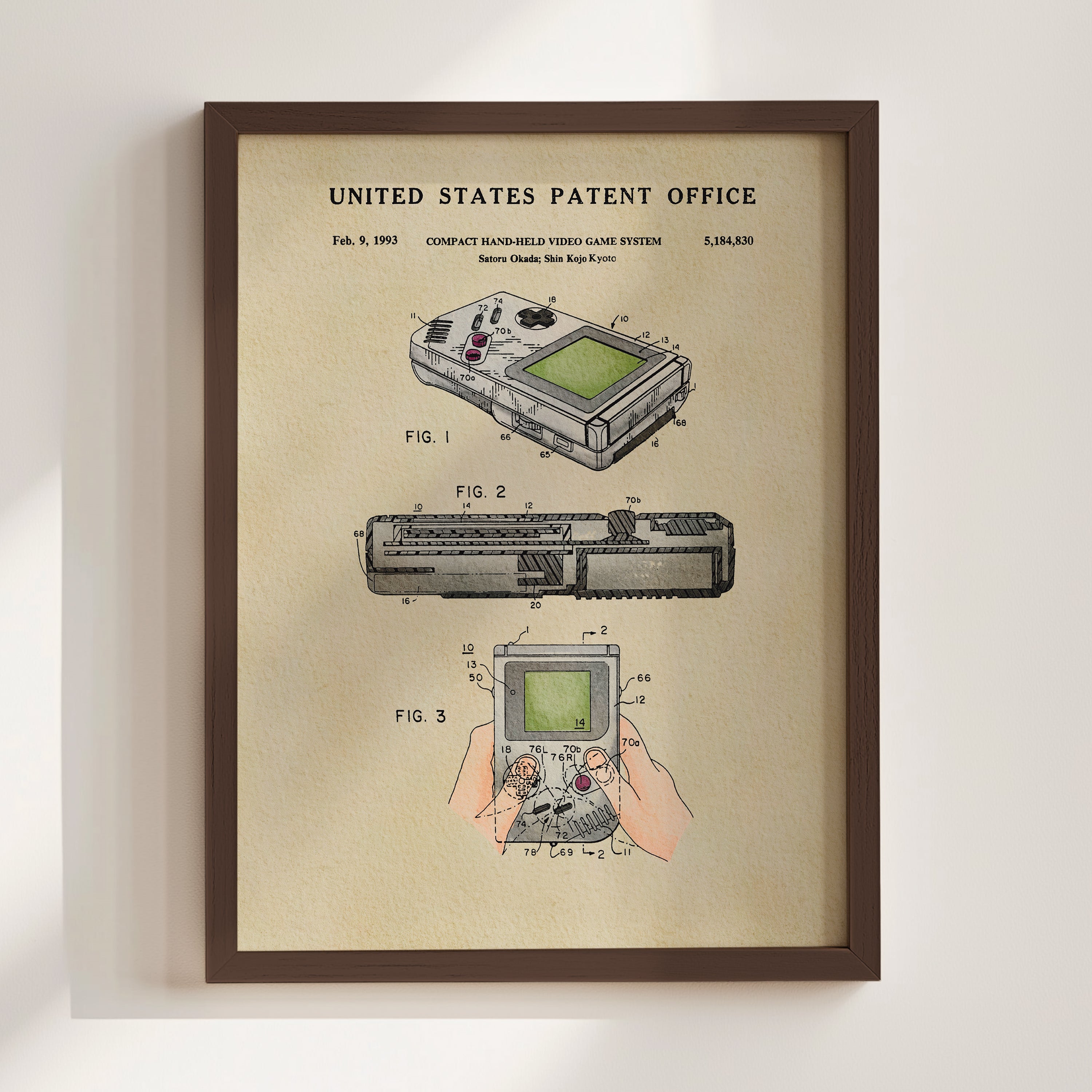 The image is a framed patent drawing depicting a compact handheld video game system, specifically the Nintendo GameCube.