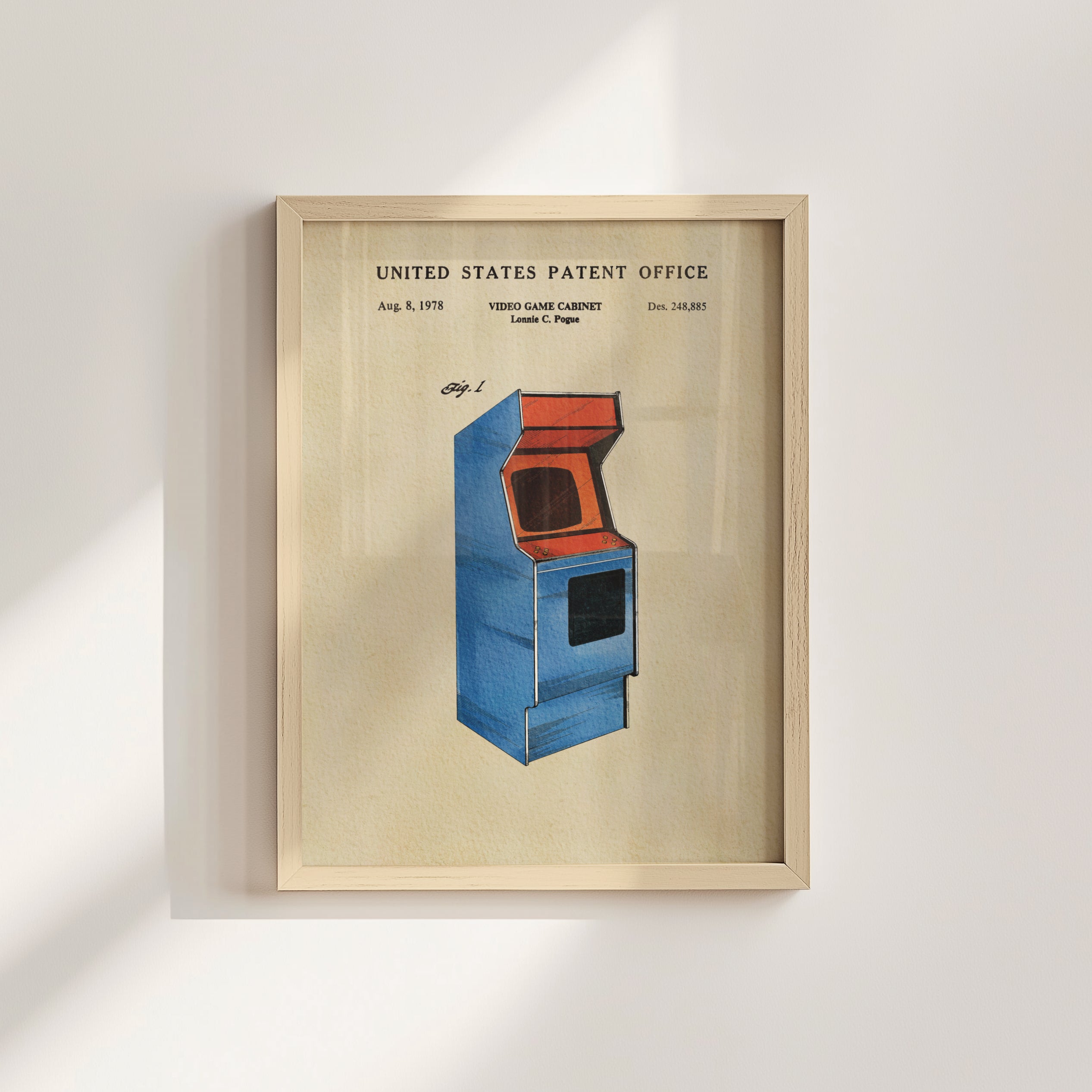 The image is a framed patent drawing of a blue arcade cabinet, depicting a retro gaming console from the 1980s.