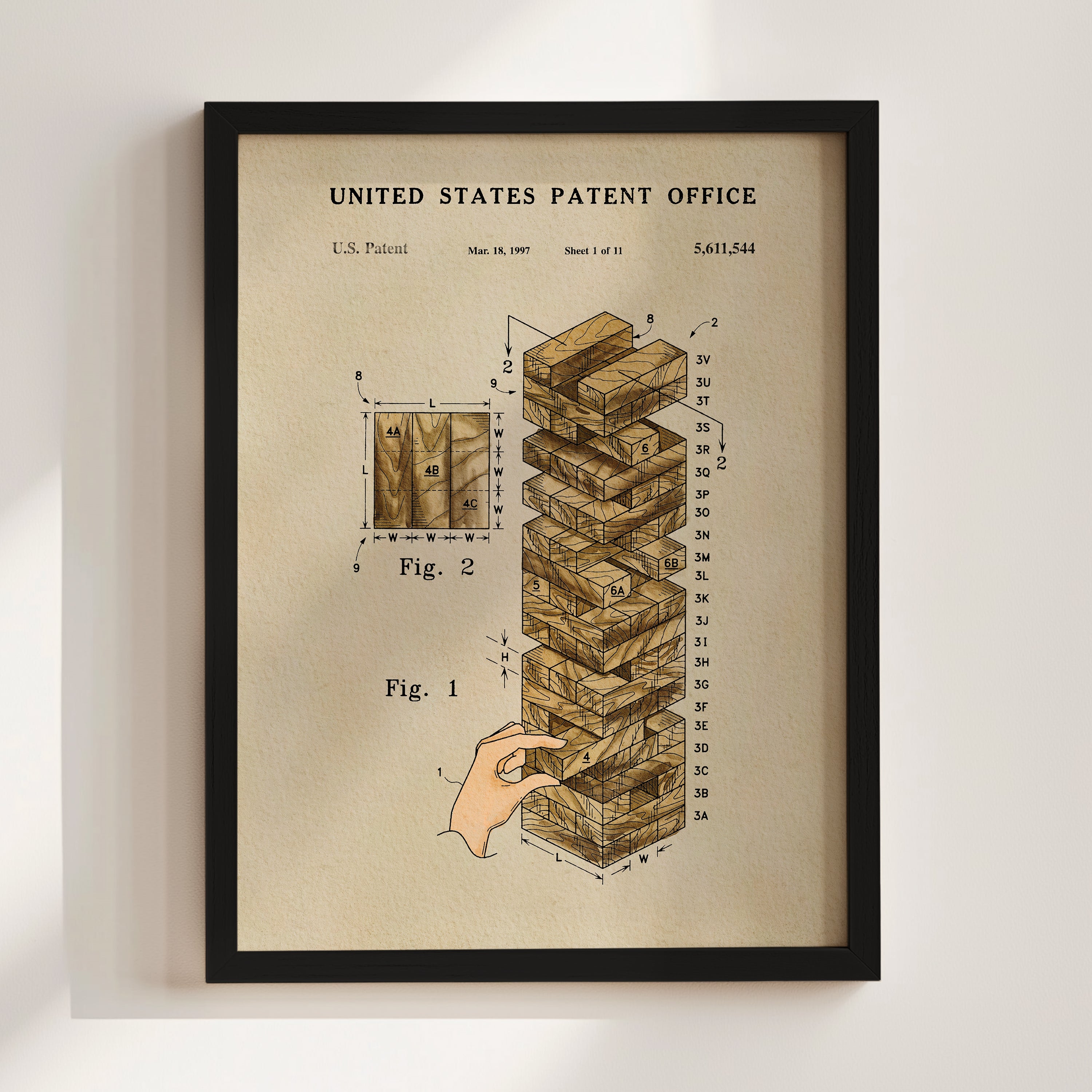 The image is a framed print depicting a hand reaching for a stack of wooden blocks, with a diagram and text indicating it is a patent drawing from the United States Patent Office.