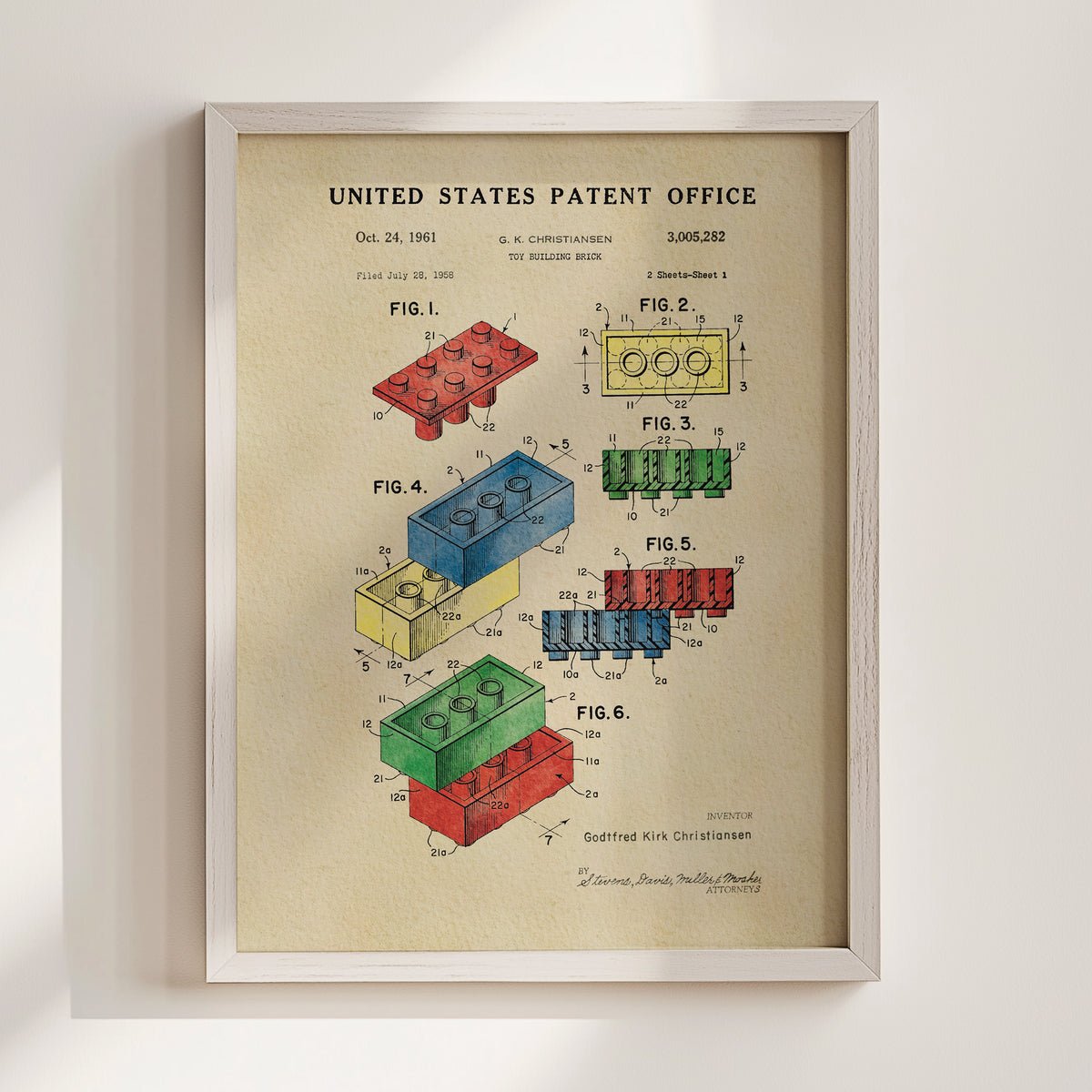 The image is a framed patent drawing depicting various Lego brick designs, including a blue brick, a red brick, and a yellow brick.