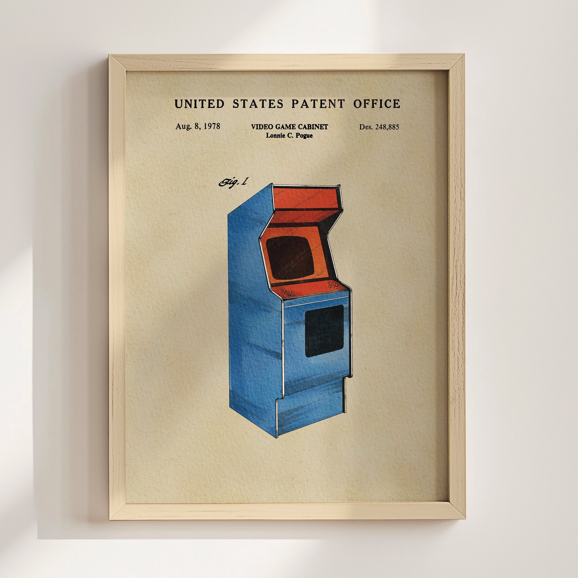 The image is a framed poster depicting a blue arcade cabinet with an orange screen, which is a vintage video game cabinet patent from the United States.