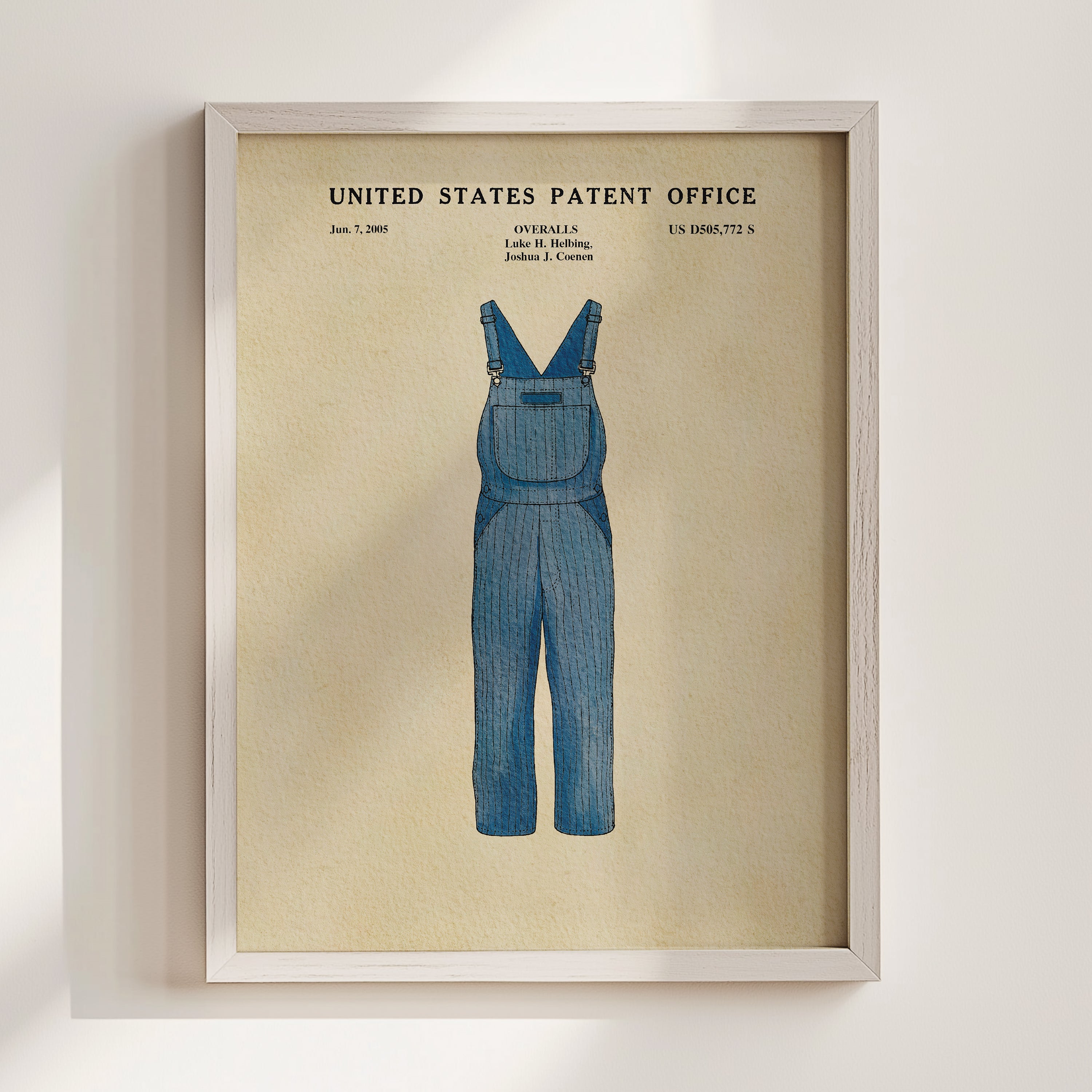 The image is a framed print of a patent application for a pair of blue overalls.