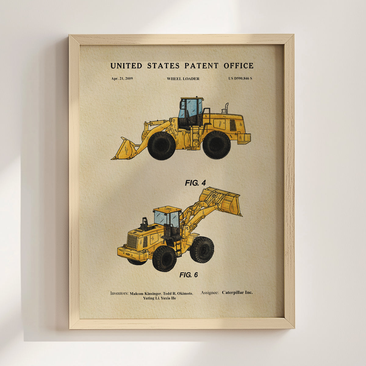 The image is a framed poster or print featuring two illustrations of wheel loaders, with text indicating that it is a patent from the United States Patent Office.