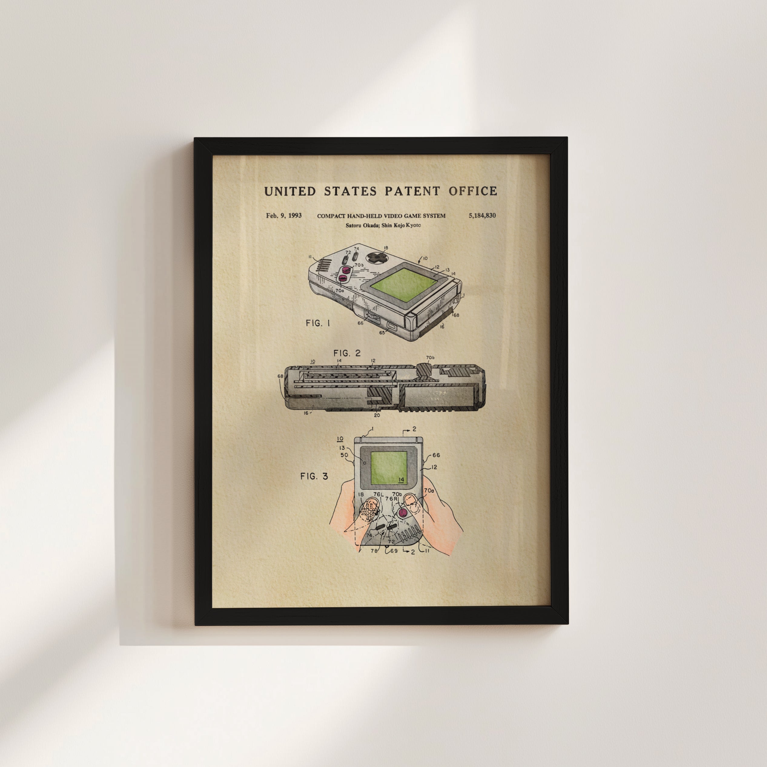 The image is a framed patent drawing depicting a handheld video game system, specifically the Nintendo GameCube, with illustrations and technical drawings.