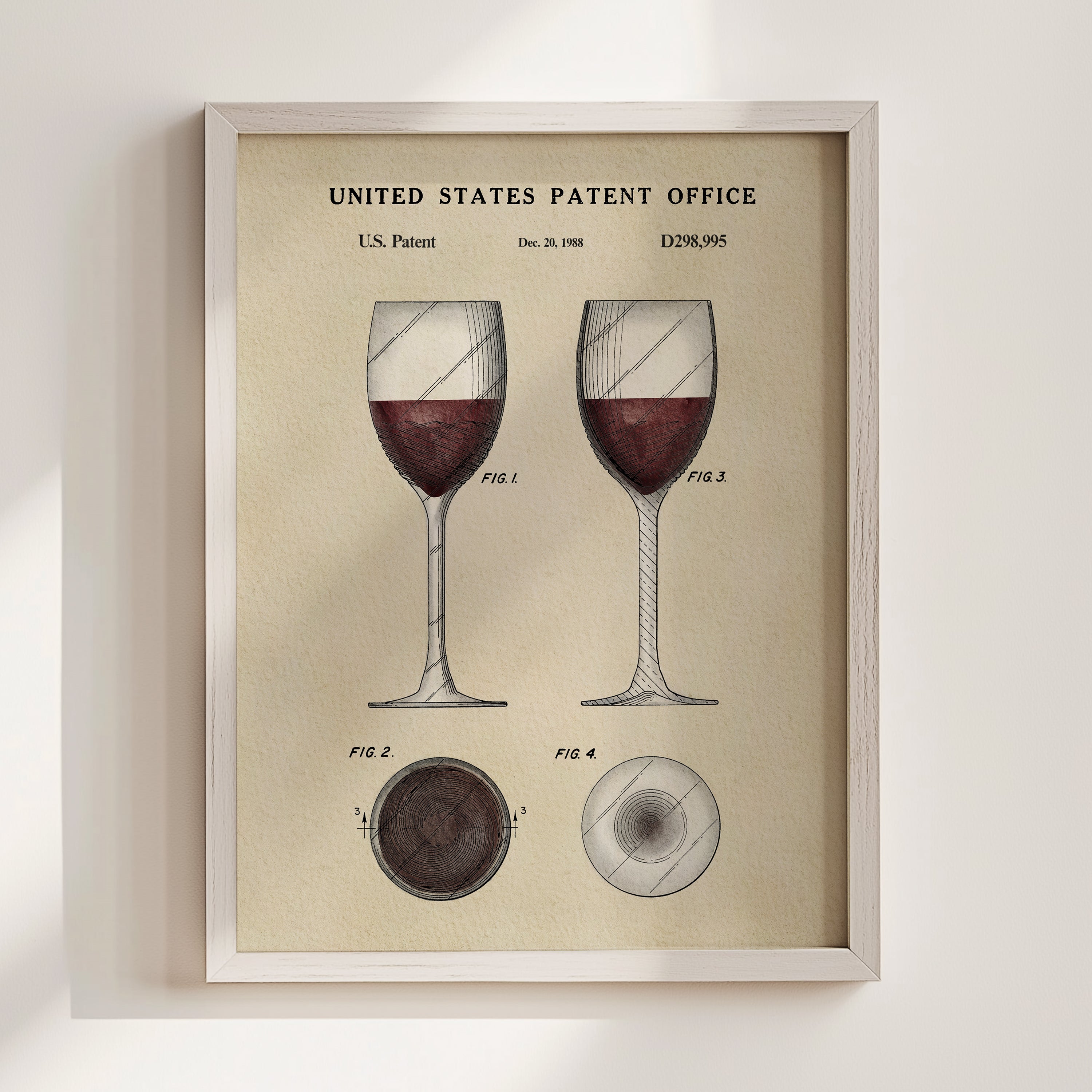 The image is a framed vintage patent illustration depicting two wine glasses with red wine, along with technical drawings and the text 
