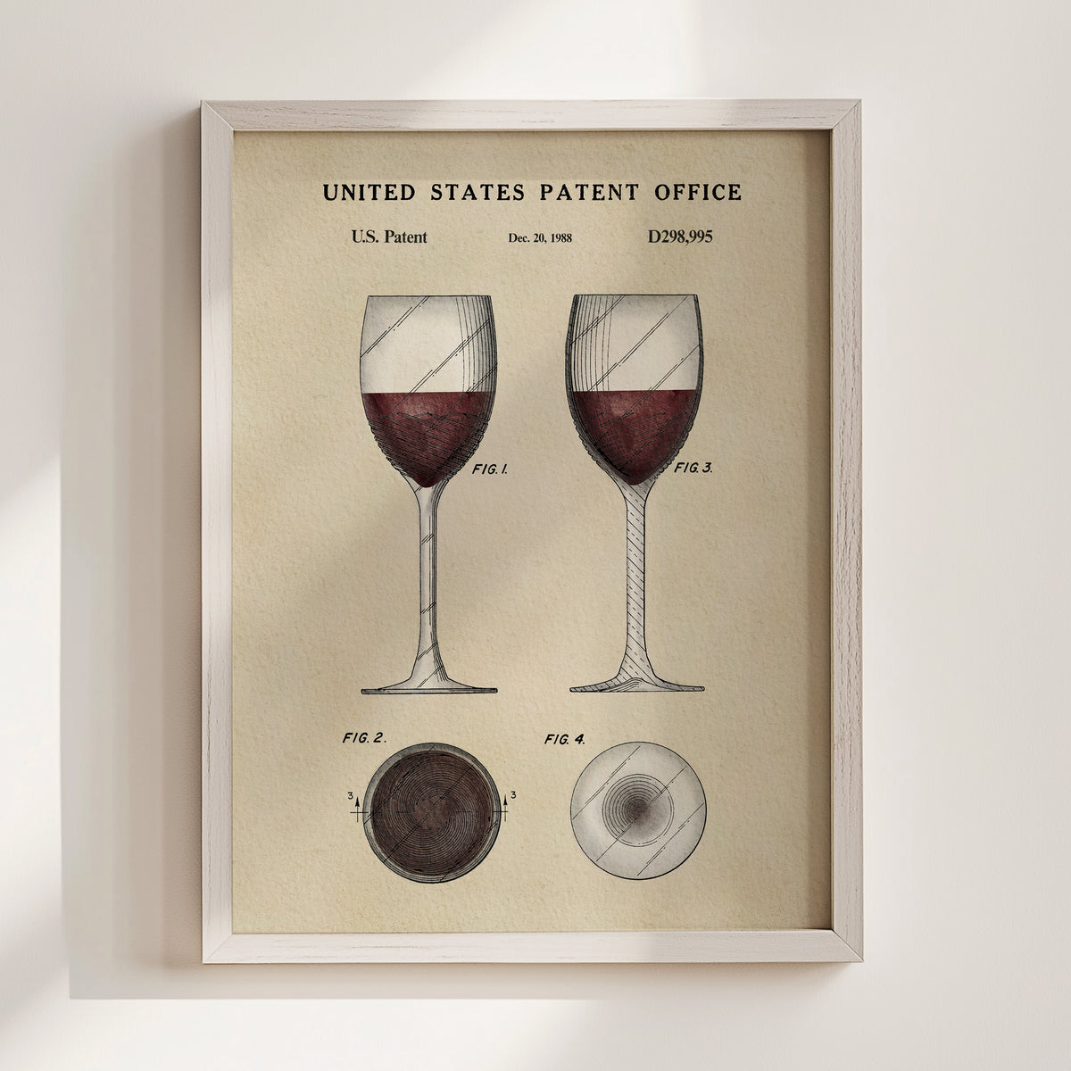 The image is a framed vintage patent illustration depicting two wine glasses with red wine, along with technical drawings and the text "United States Patent Office" and "D28985".
