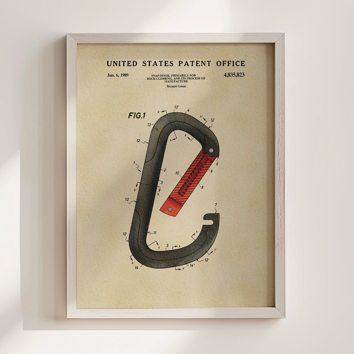 The image is a framed patent drawing depicting a red and black carabiner, a type of hook used for securing items to carabiners.