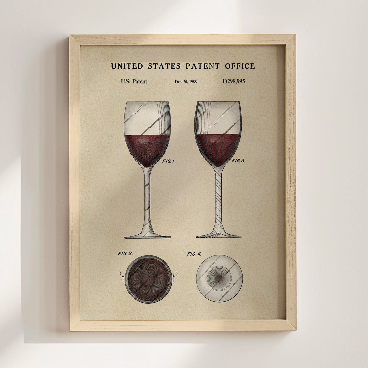 The image is a framed vintage patent illustration depicting two wine glasses with red wine, along with technical drawings and the text "United States Patent Office" and "D28985".
