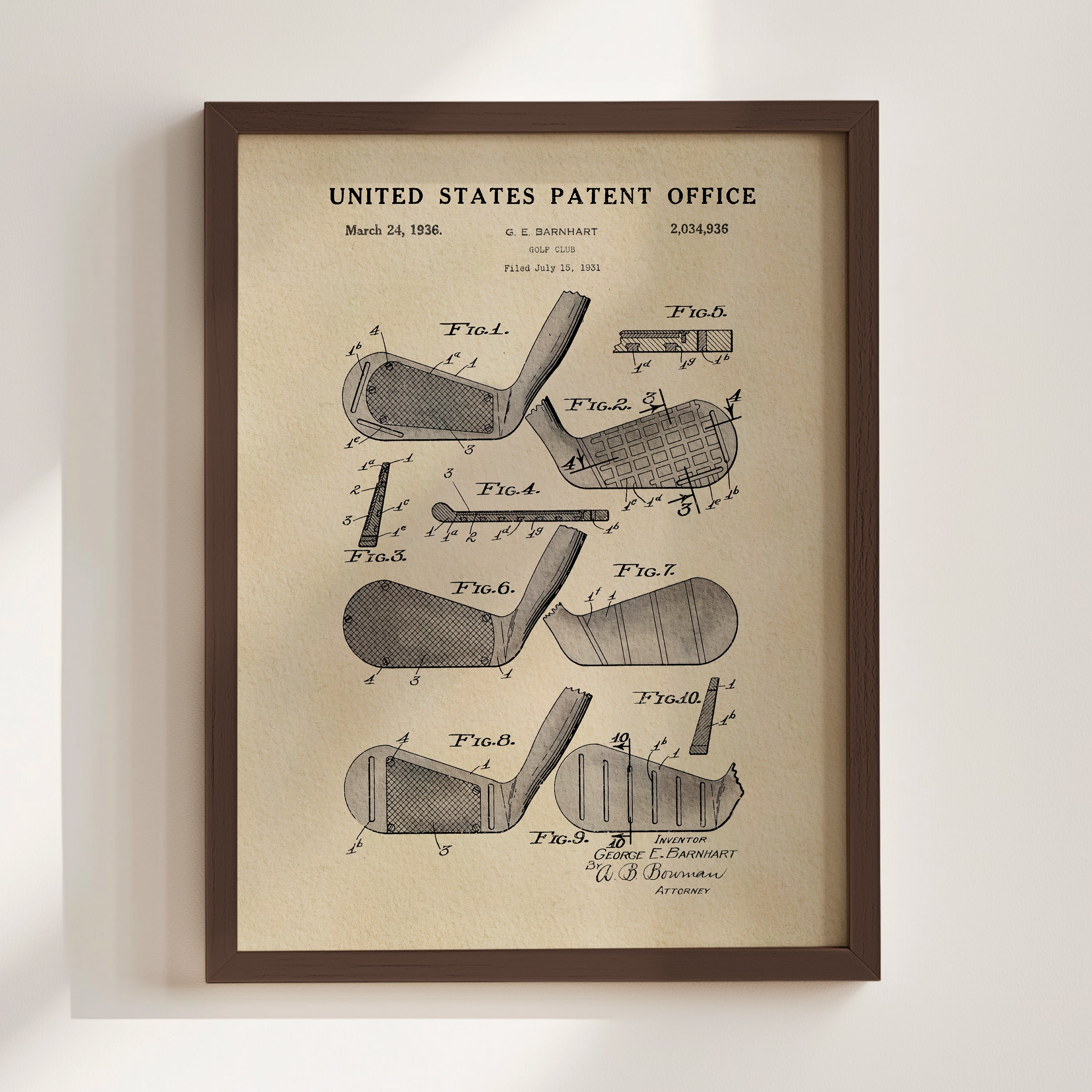 The image is a framed vintage patent drawing of a golf club, depicting various parts of the club such as the head, shaft, and grip.