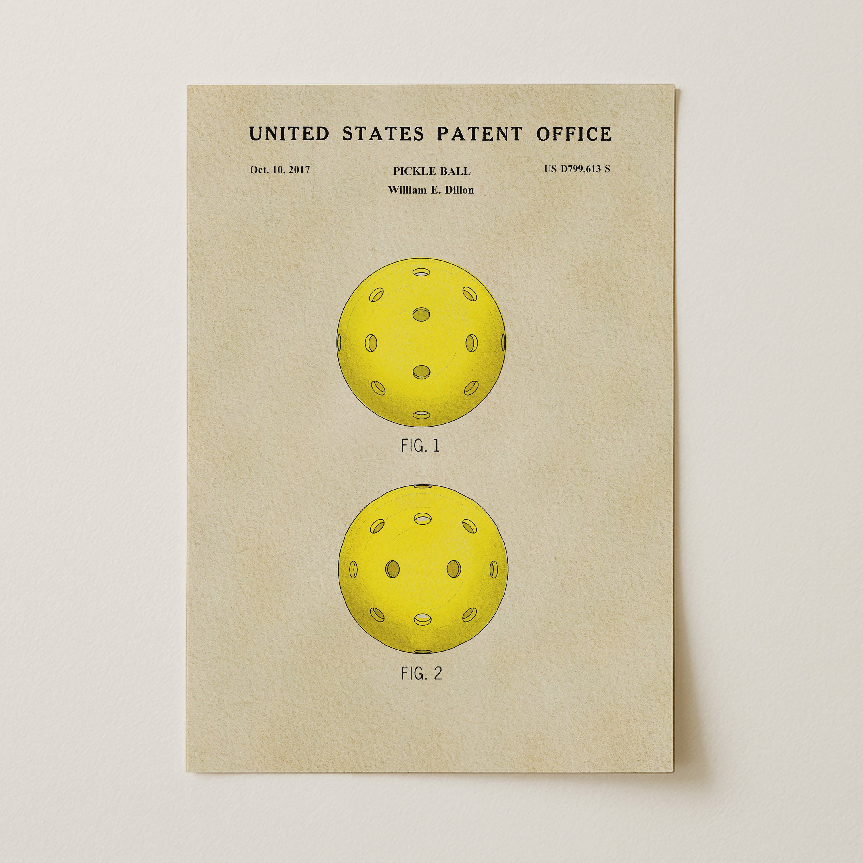 The image is a patent drawing of a yellow pickle ball, depicting two different designs of the ball.