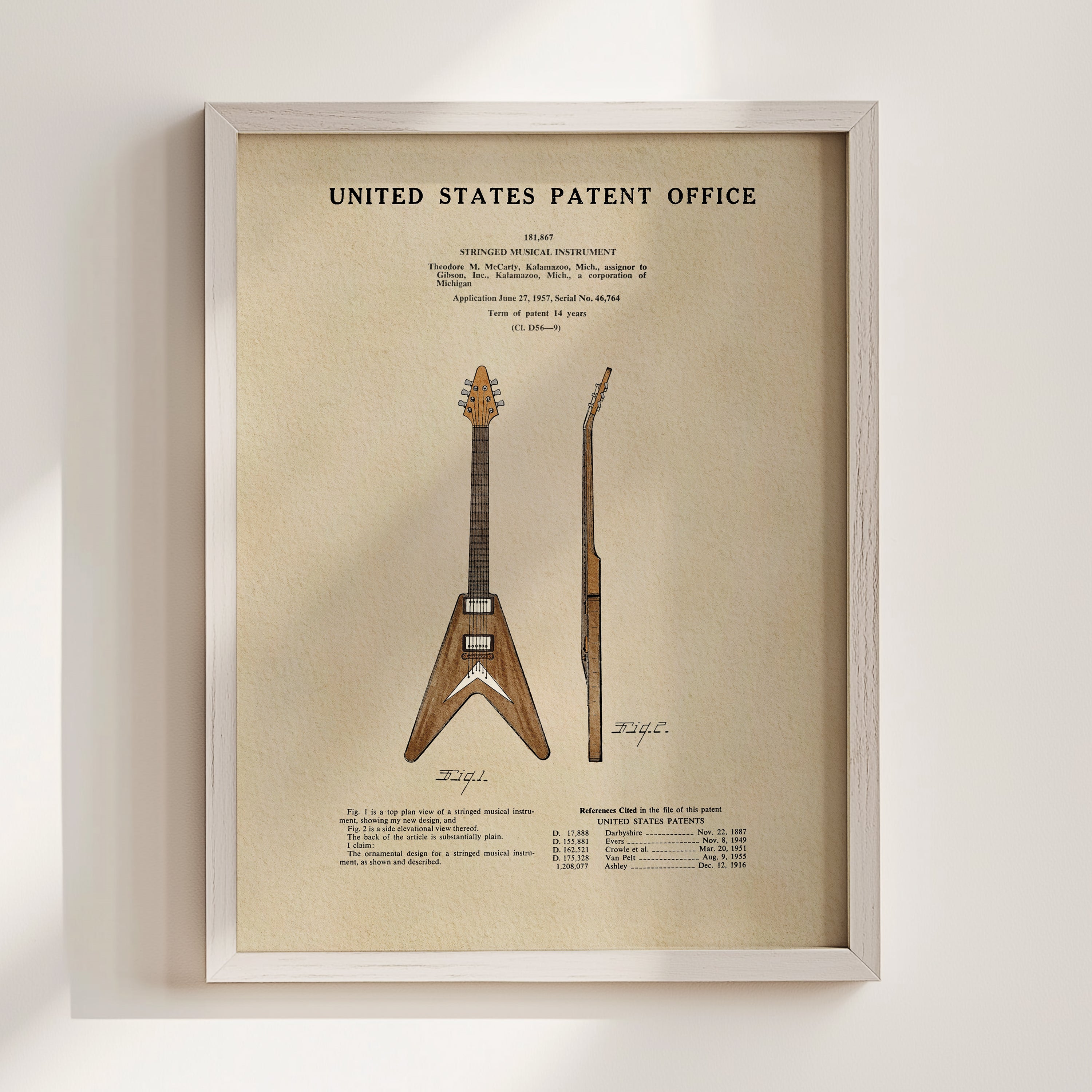 The image is a framed print of a patent application for a guitar, featuring a detailed illustration of the guitar design and specifications.