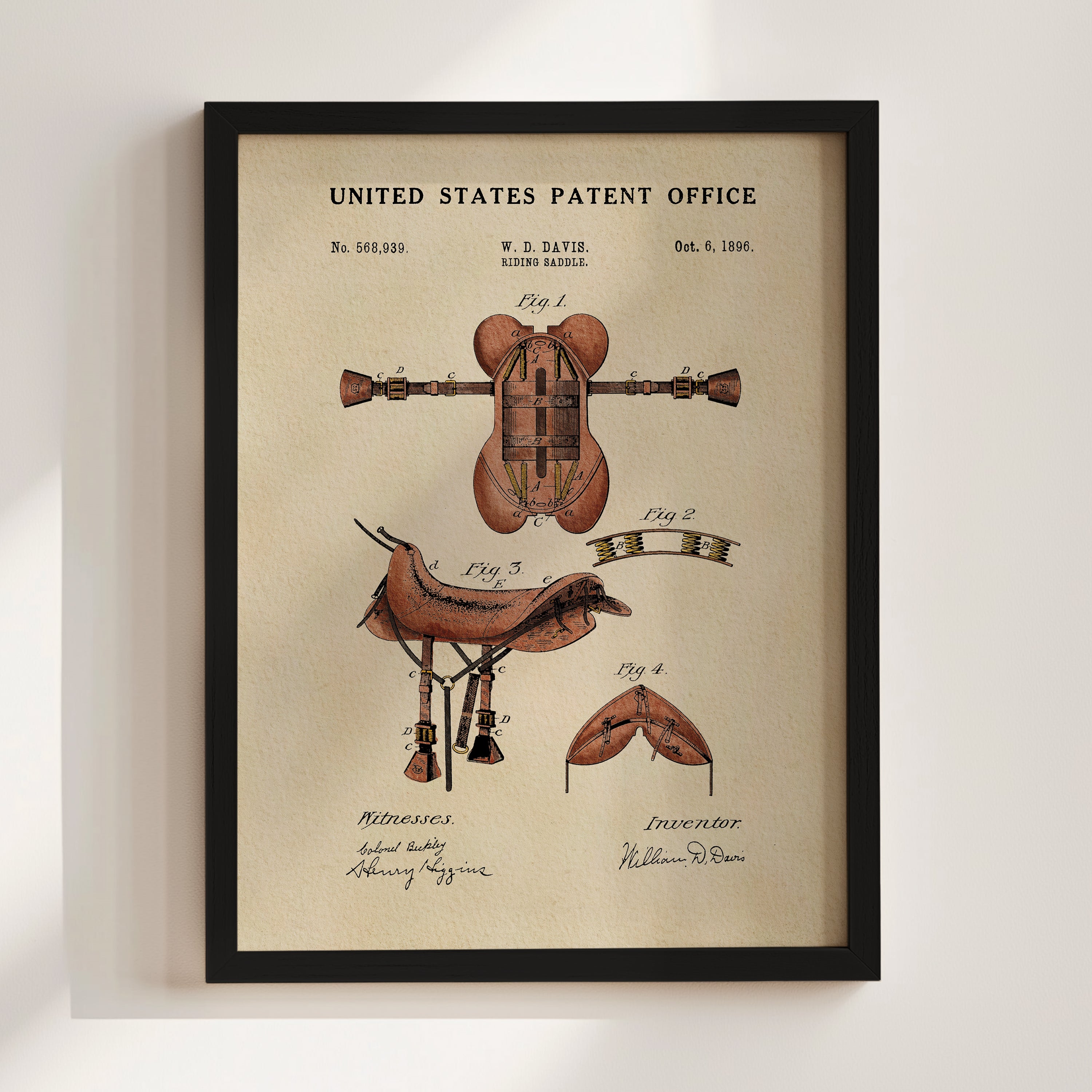 The image is a framed print of a United States patent office patent from 1885, featuring an illustration of a horse saddle and other patent-related drawings.