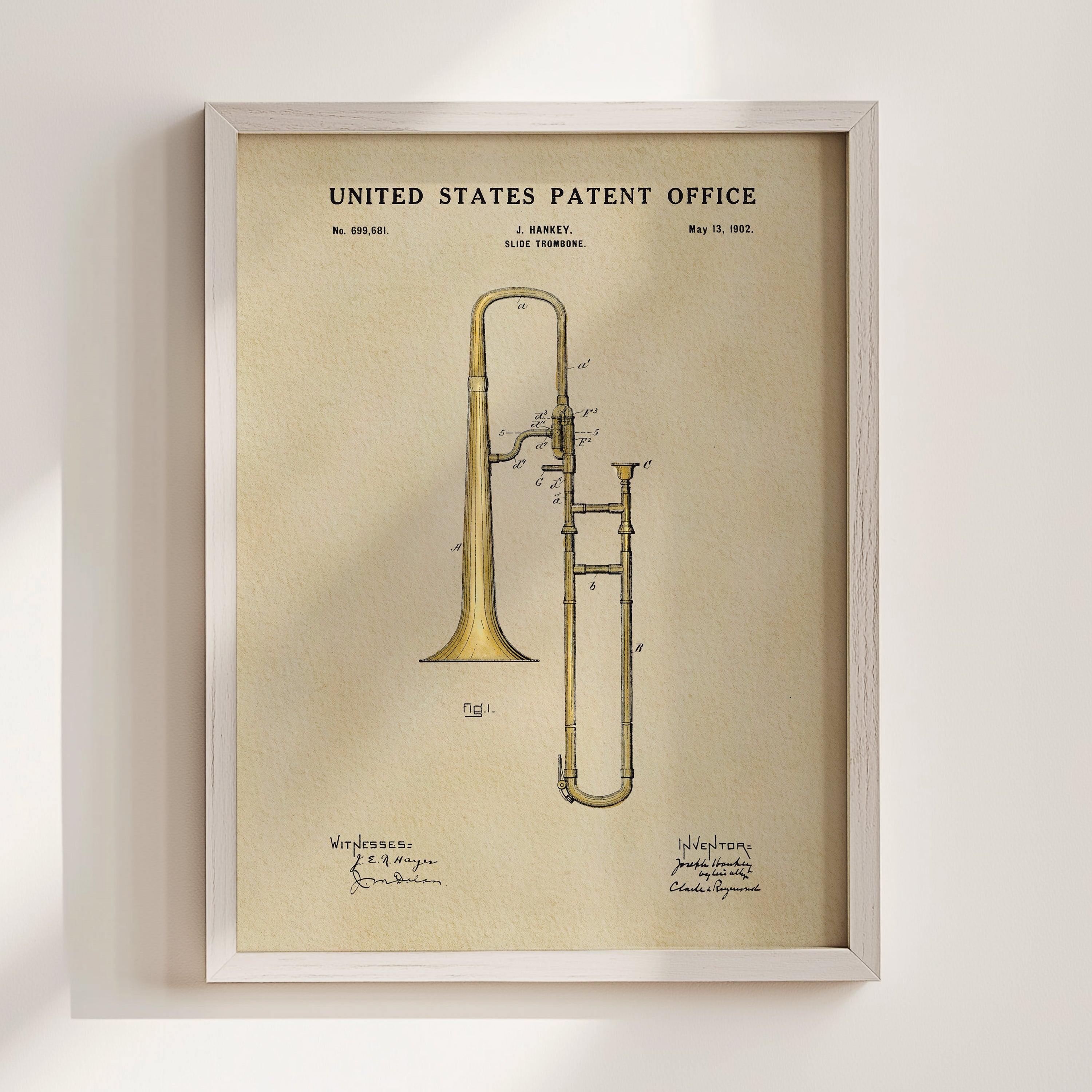 The image is a framed vintage patent drawing of a trumpet, depicting the instrument in a detailed and artistic manner.